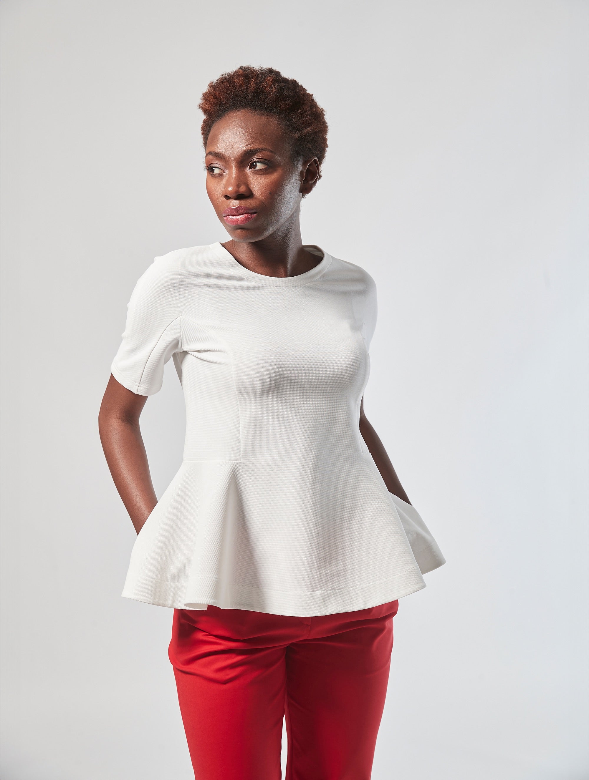 Bluse aus festem Baumwoll-Mix, tailliertem Schnitt mit peplum Schößchen und weit ausgestelltem Saum