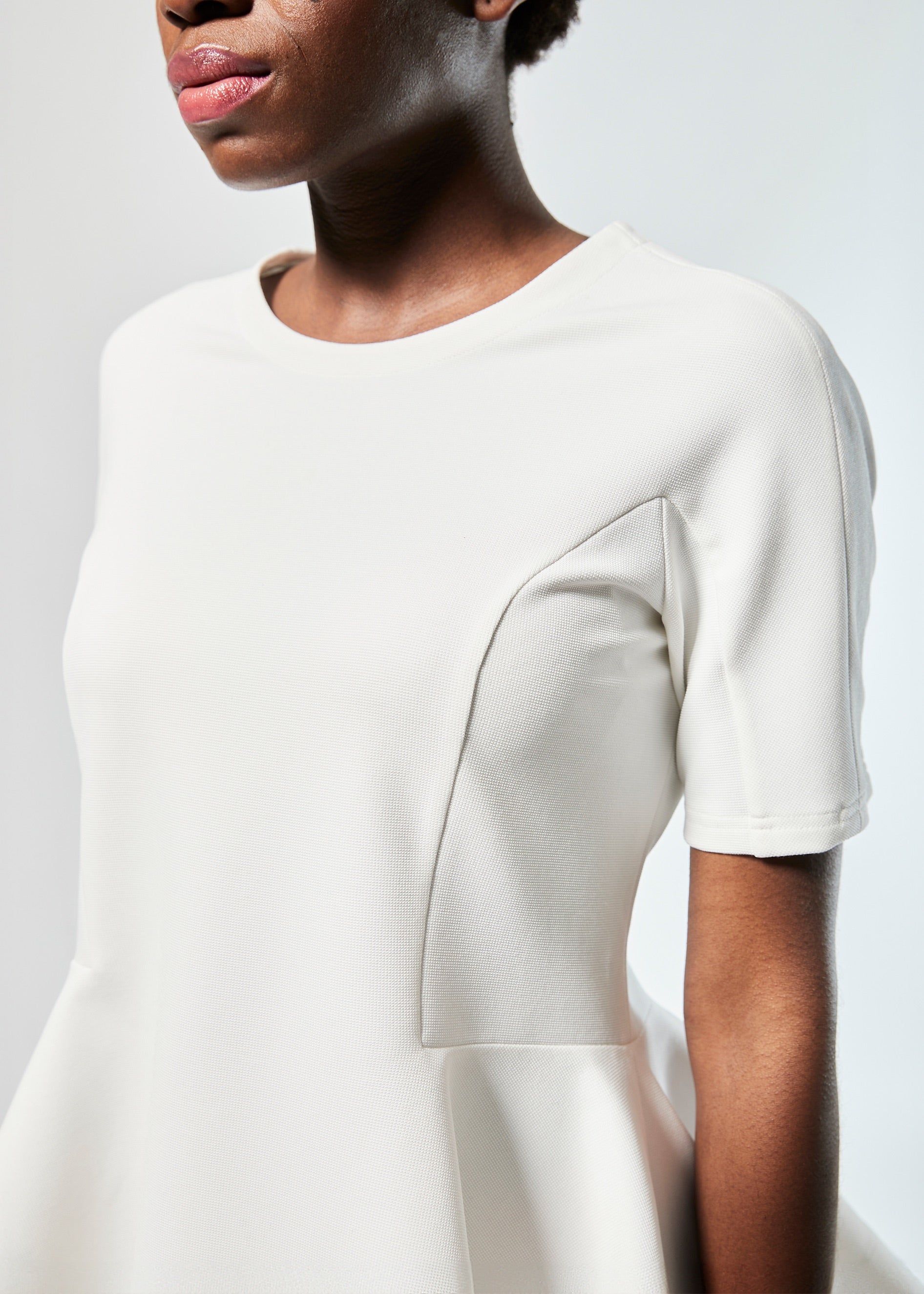 Bluse aus festem Baumwoll-Mix, tailliertem Schnitt mit peplum Schößchen und weit ausgestelltem Saum