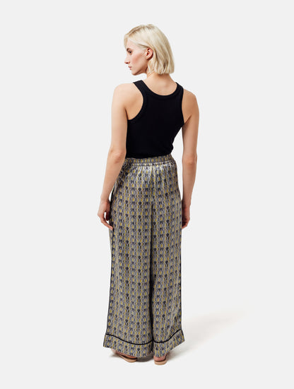 Bedruckte Satin-Seidenhose mit weitem Bein im Pyjama-Stil, elastischem Bund, Seitentaschen und schwarzen Paspeln. Hergestellt aus Naturfaser.