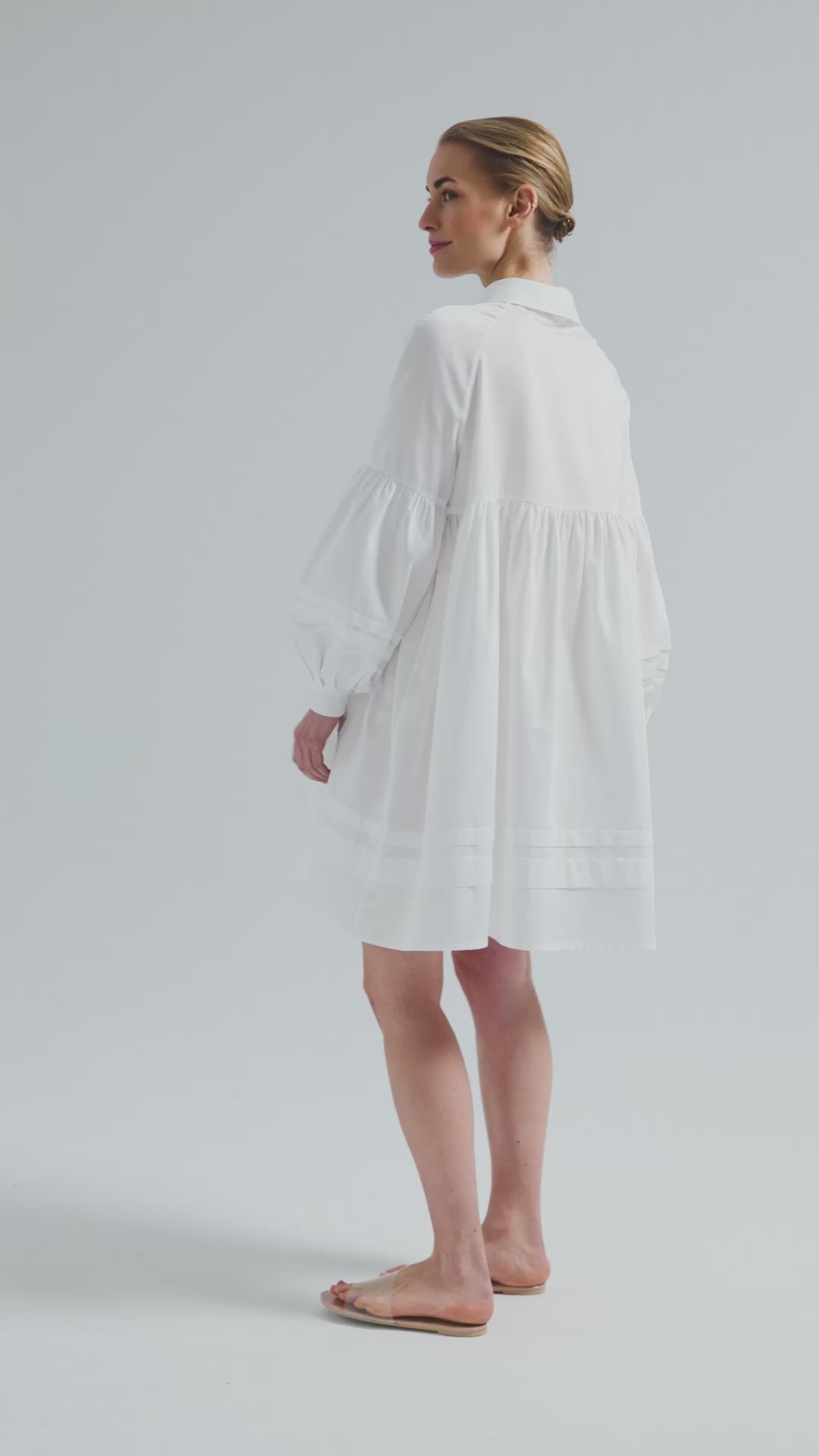Weites Hemdkragenkleid mit weiten Laternenärmeln, Biesen an der Brust, Ärmeln, aufgesetzenTaschen und Saumende, sowie verdeckter Knopfleiste. Gefertigt aus Premiumbaumwolle mit Satin-Touch.