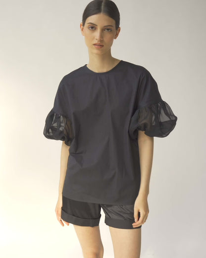 Schwarze Bluse mit Rundhalsausschnitt, Organza-Ärmeln, Seitenschlitzen und versteckten Seitentaschen
