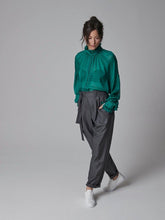 Locker geschnittene Bundfaltenhose aus weichem Wolle-Seiden-Mix sowie seitlichen Eingriffstaschen und Bindegürtel