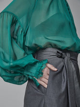 Locker geschnittene Bundfaltenhose aus weichem Wolle-Seiden-Mix sowie seitlichen Eingriffstaschen und Bindegürtel