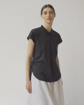 Schwarze, ärmellose Bluse mit Flügelkragen und Knöpfen auf der Vorderseite neben der Seitennaht